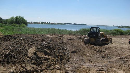 Metoda pentru a cistiga teren construibil: toarna moloz pe malul Lacului Cernica